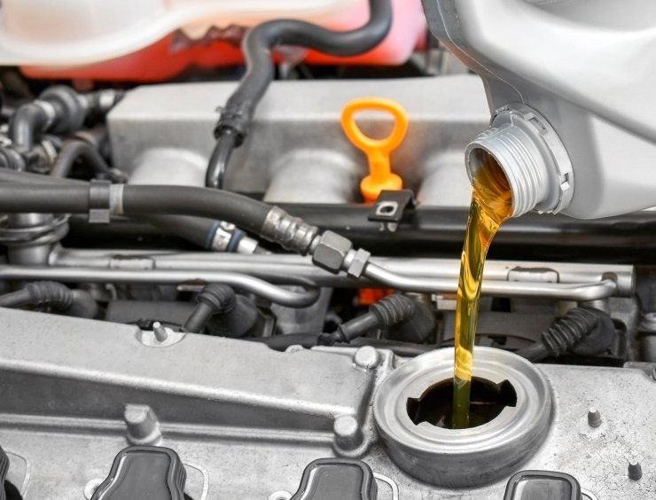 gros plan d'huile coulant dans un moteur de voiture